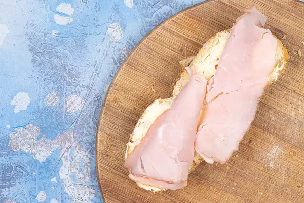 Ham sandwich served on the round wooden board with copy space