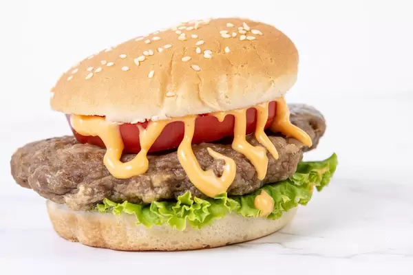 Hamburger with Tomato Lettuce and Sauce above white background (Flip 2019) (Flip 2019)