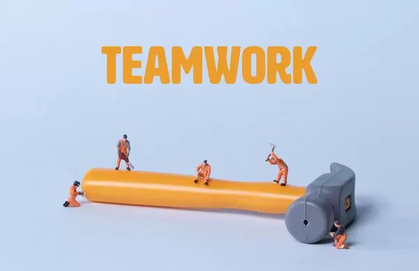 Hammer with miniature workers and Teamwork text
