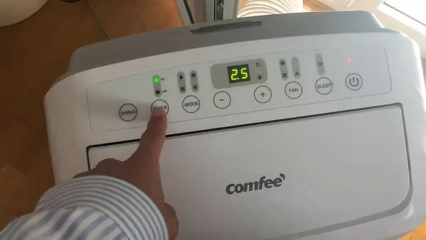 Hand betätigt die Timer-Funktion des Comfee - Luftentfeuchter