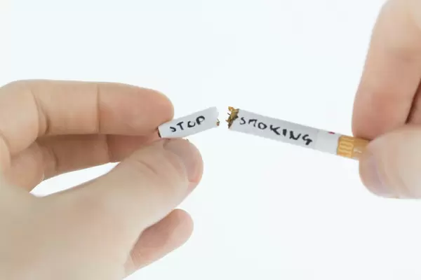 Hand breaking a cigarette in half