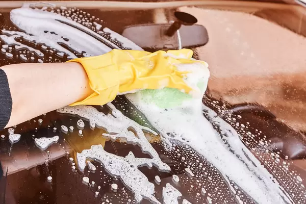 Hand car wash - washing windshield with sponge
