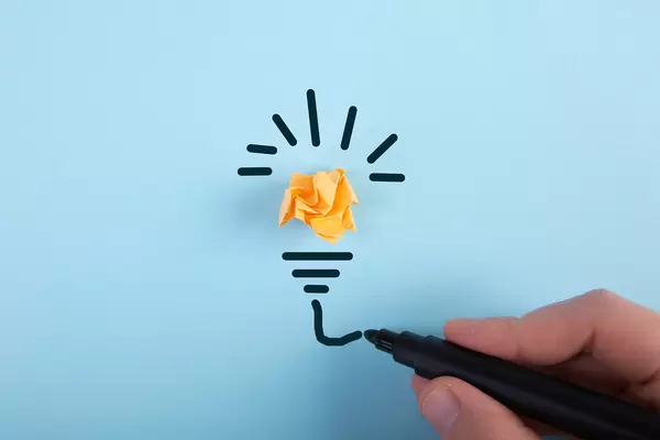 Hand drawing lightbulb on blue background