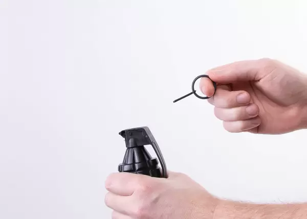 Hand grenade in a man's hand with the pin pulled