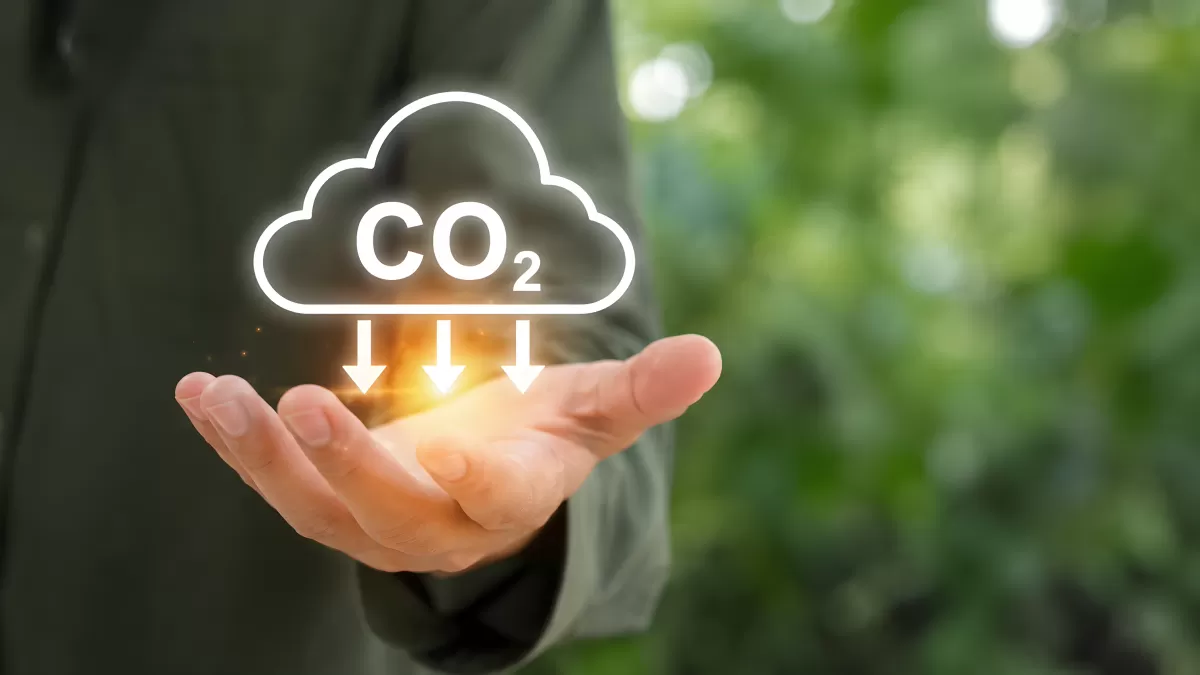 Hand hält CO2-Reduktion als leuchtendes Symbol