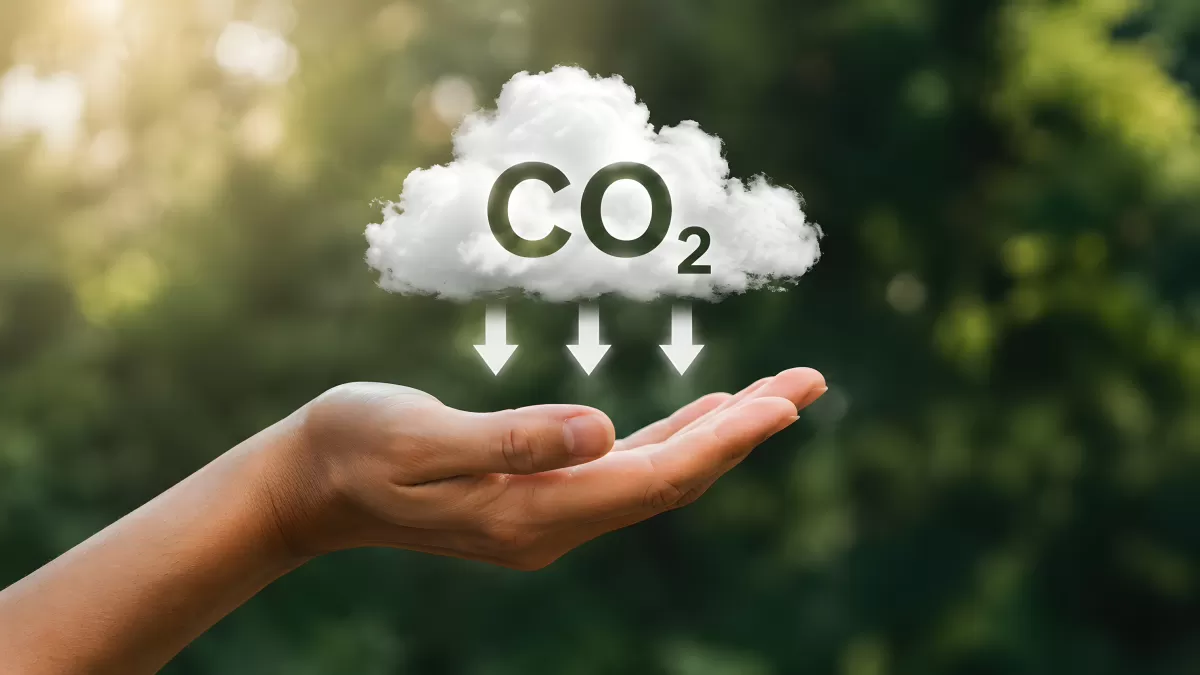 Hand hält CO2-Wolke mit Pfeilen nach unten