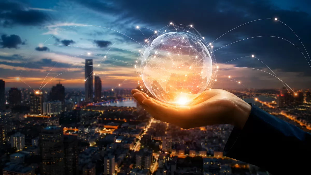 Hand hält digitalen Globus über beleuchteter Skyline