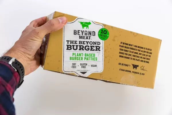 Hand hält Beyond Meat veganische, pflanzliche glutenfreie Burger-Pastetchen in Packung