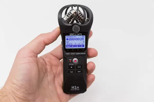 Hand hält den Zoom H1n Handy Recorder während eine Aufnahme auf dem Display angezeigt wird