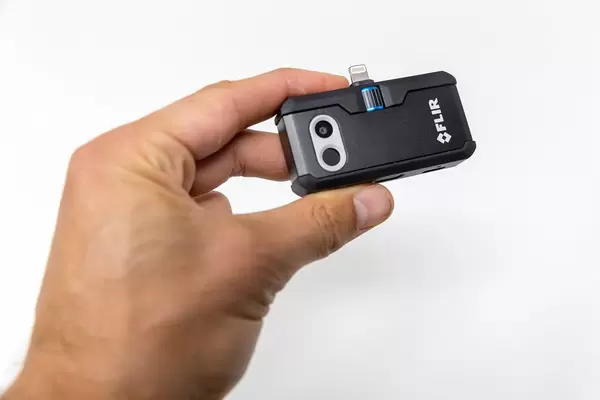 Hand hält die Wärmebildkamera FLIR ONE PRO LT für Android mit USB-C Anschluss, vor weißem Hintergrund