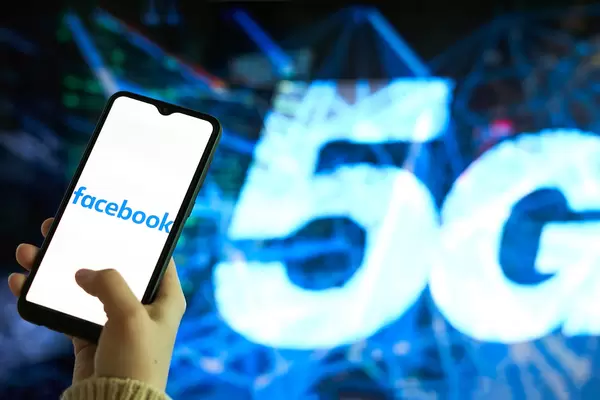 Hand hält ein Smartphone mit dem Facebook Logo auf dem Display und "5G" als Hintergrund