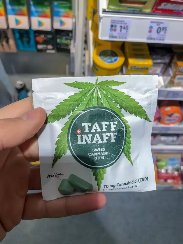Hand hält Kaugummipacking "Taff Inaff Swiss Cannabis Gum" mit CBD Gehalt im Supermarkt