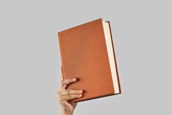 Hand holding a book. Concepts of book reading, online education, distance learning or self-education