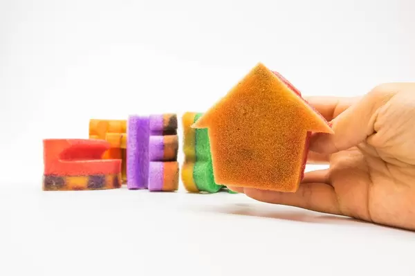 Hand holding a house shaped sponge