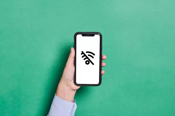 Hand holding a mobile phone with No WiFi sign