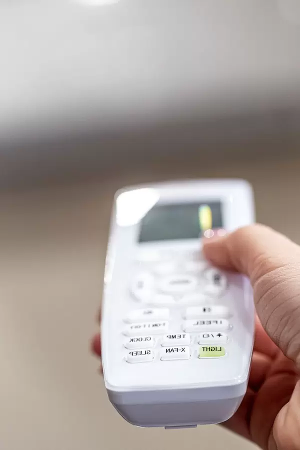 Hand holding a remote control of air conditioner (Flip 2020)