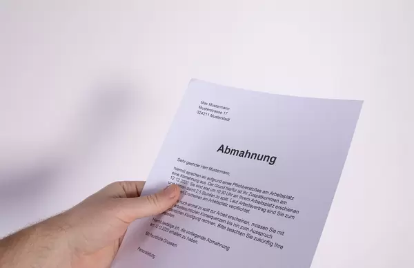 Hand holding Abmahnung document