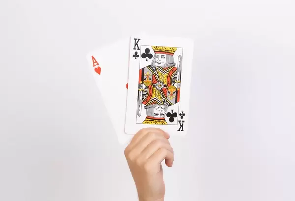 Hand holding ace and king playing cards