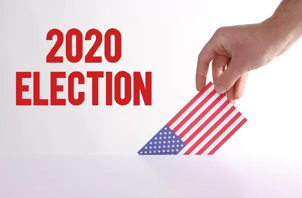 Hand holding American flag with 2020 Election text