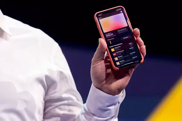 Hand holding an iPhone showing on its display a list of transactions made with the Apple Card