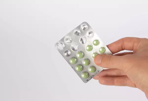 Hand holding blister with pills