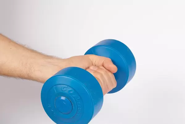 Hand holding blue dumbbell on white background