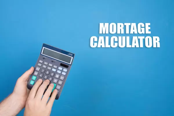 Hand holding calculator and Mortage Calculator text on blue background