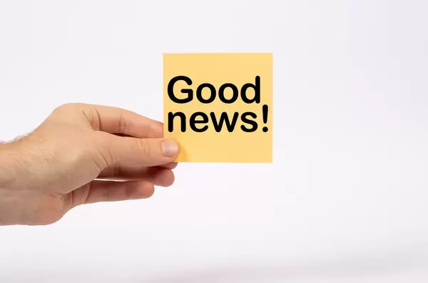 Hand holding card with text Good news!