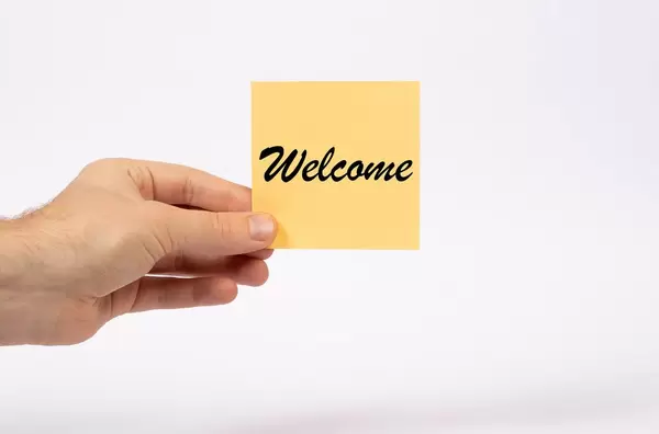 Hand holding card with text Welcome