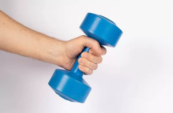 Hand holding dumbbell on white background