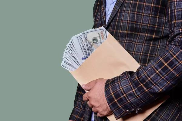 Hand holding envelope and banknotes