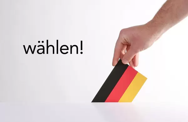 Hand holding German flag with wählen text