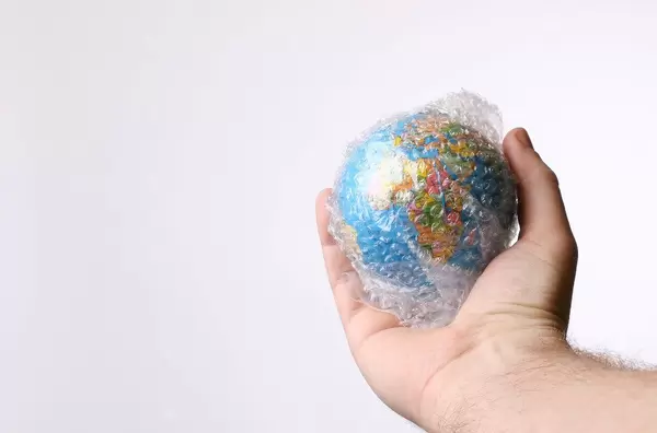 Hand holding globe packed in bubble wrap