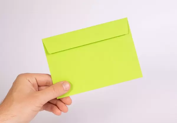 Hand holding green envelope