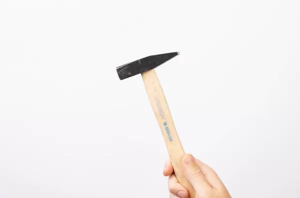 Hand holding hammer on white background (Flip 2019)
