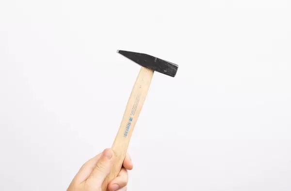 Hand holding hammer on white background