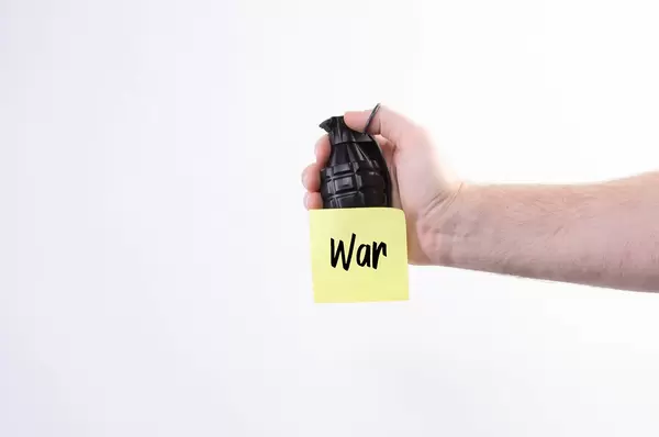 Hand holding hand grenade with War text