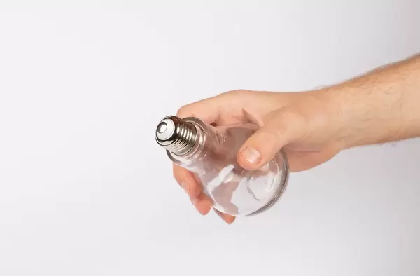 Hand holding lightbulb on white background (Flip 2019)