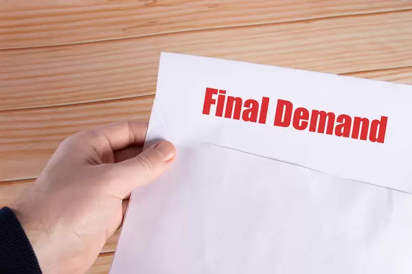 Hand holding open envelope with Final Demand text