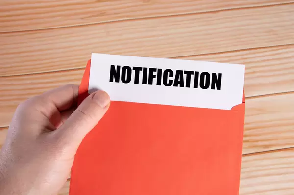 Hand holding open envelope with Notification text
