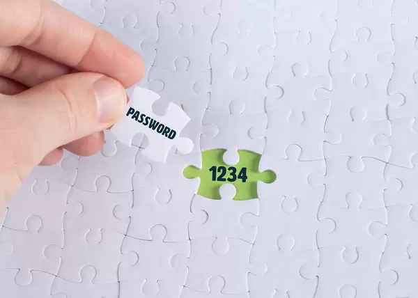 Hand holding piece of jigsaw puzzle with word password & 1234