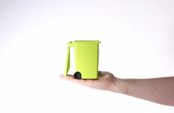 Hand holding plastic container for garbage