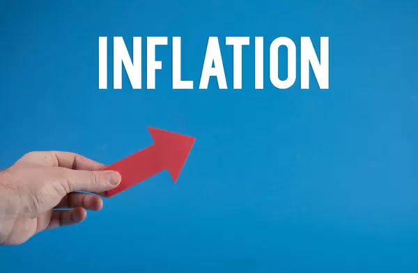 Hand holding red arrow and Inflation text on blue background