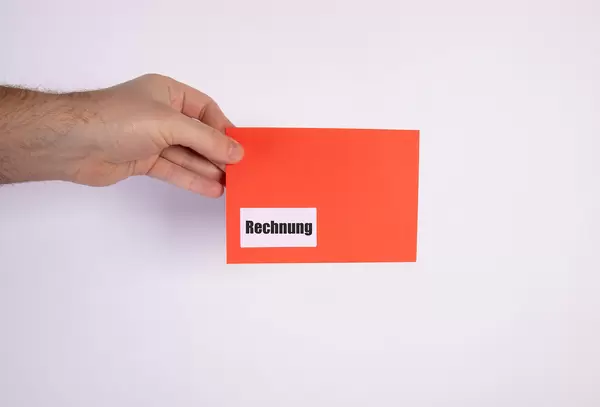 Hand holding red envelope with Rechnung
