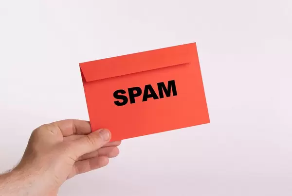 Hand holding red envelope with SPAM text