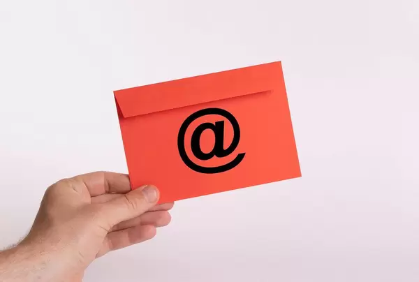 Hand holding red envelope with @ symbol