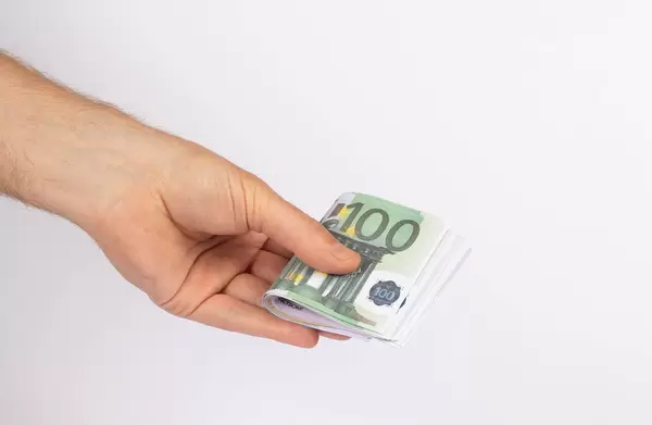 Hand holding stack of Euro bills