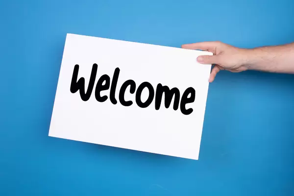 Hand holding white banner with Welcome text on blue background