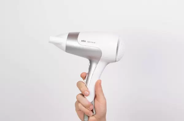 Hand holding white blow dryer