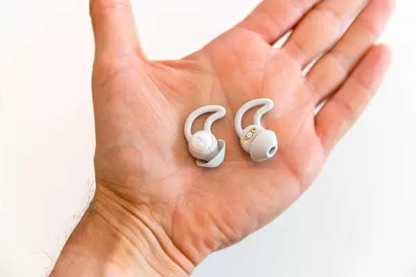 Hand holds grey Bose Noise-Masking Sleepbuds, designed to mask noise and disturbances